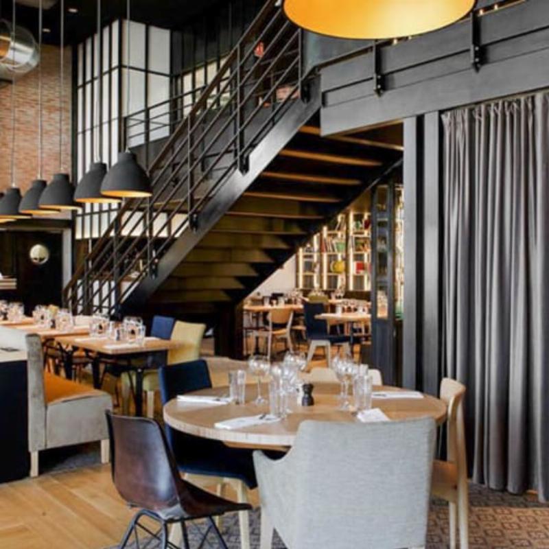 Interieur d'un restaurant chic de Clermont-Ferrand avec une ambiance chaleureuse et des clients souriants